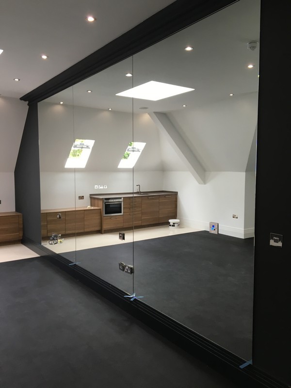 Frameless glass partition in loft conversion by Ladbroke Grove glaziers