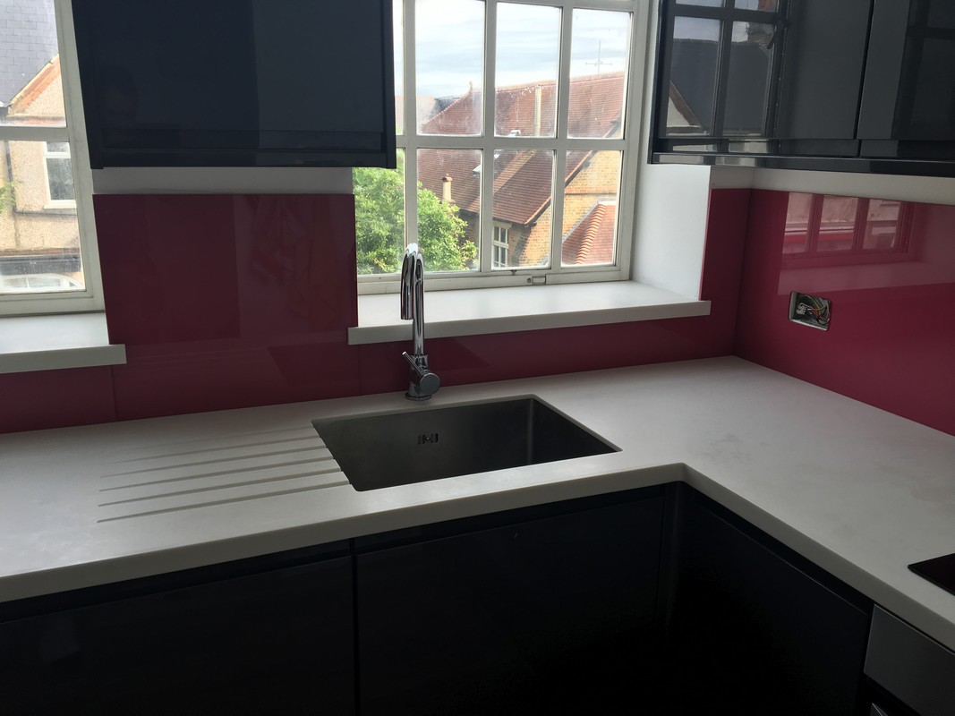 Deep plum coloured glass splashback in modern Ladbroke Grove kitchen